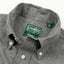 A closeup of the grey flannel collar with a button down collar and white buttons.