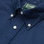 A navy-colored, button down 100% cotton Oxford shirt with an unlined collar, white buttons, green label, and stitching.